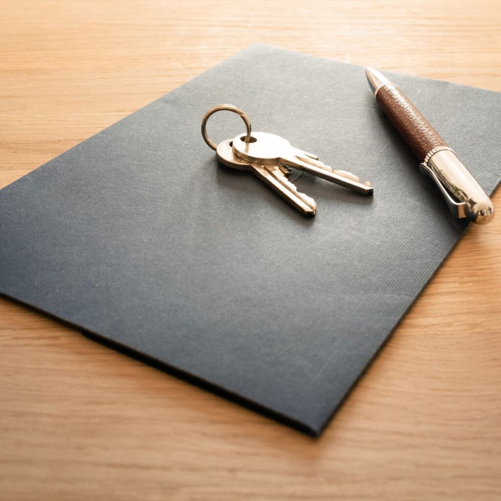 Keys and a pen on a folder