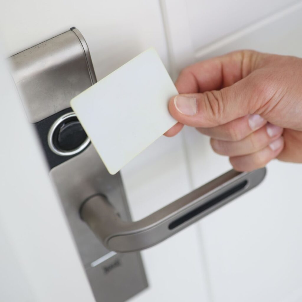 a person using a key card on a door lock