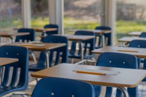 school desks with pencils and a piece of paper